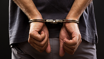 A man in handcuffs holds his hands together